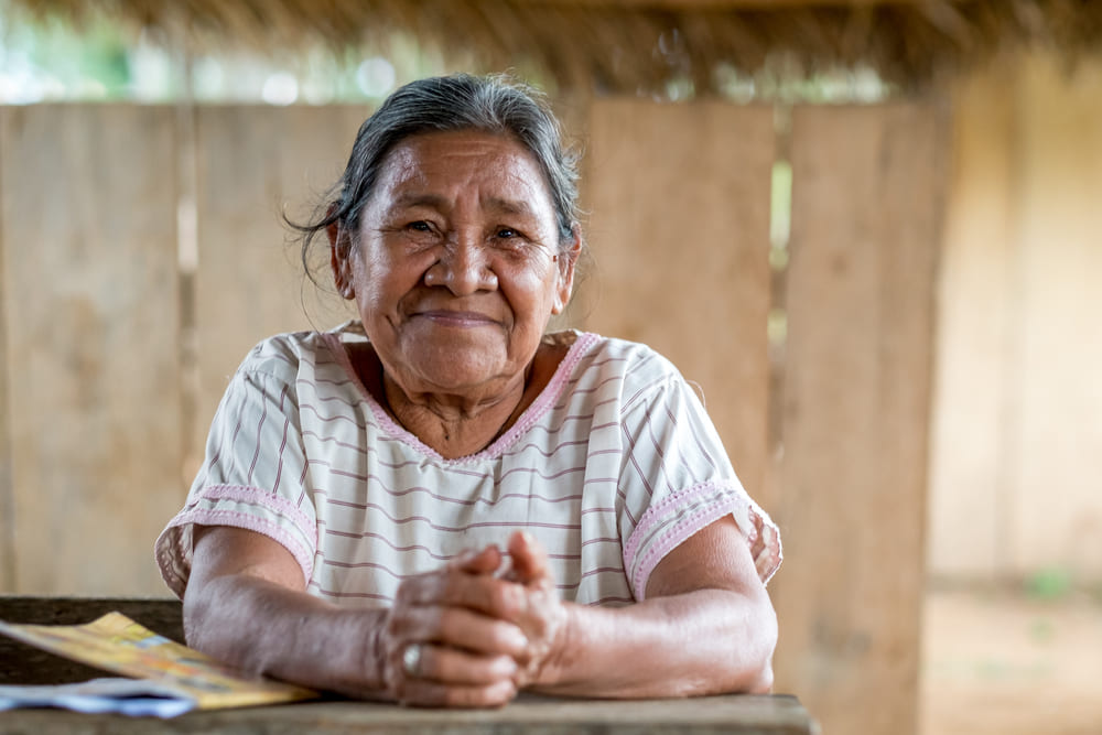 Senhora sentada feliz porque teve o bpc loas reativado pelo escritório.