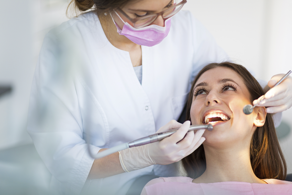 Uma dentista consultando a paciente e pensando na aposentadoria especial do dentista