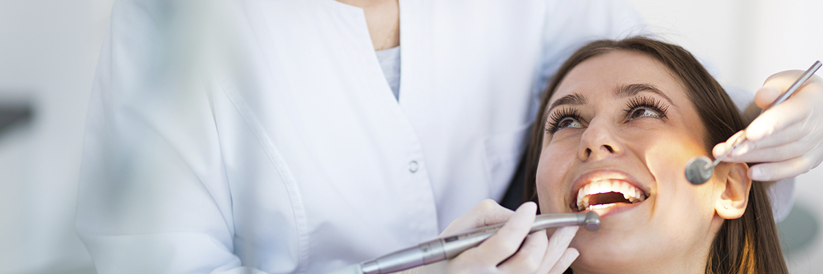 Uma dentista consultando a paciente e pensando na aposentadoria especial do dentista