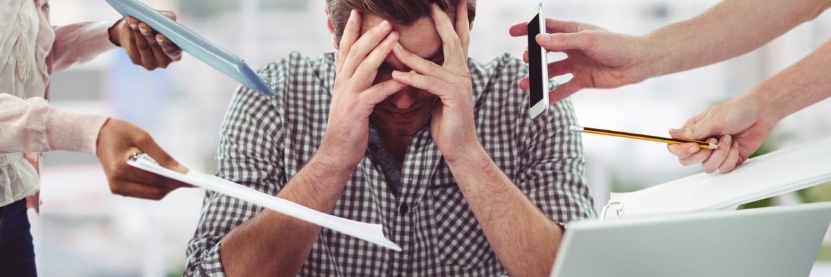 Stressed man frustrated with electronic devices Stressed man frustrated with electronic devices in office