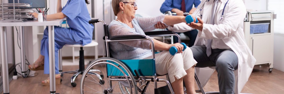 Handicapped patient getting help from physical therapist Handicapped patient getting help from physical therapist. Elderly invalid patients in hospital following rehabilitation treatment with help from medical personal.