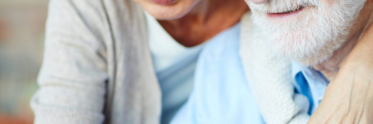 Senior man and woman having nostalgic time while looking through photos