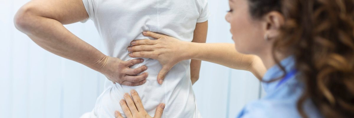 Physiotherapist doing healing treatment on womans back. Back pain patient, treatment, medical doctor, massage therapist.office syndrome